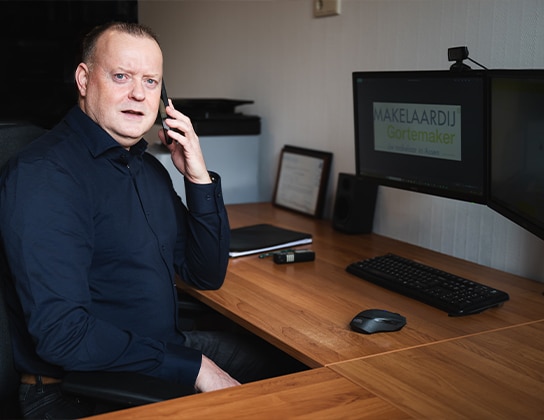 Makelaar beantwoordt telefonisch vragen van klanten op kantoor in Assen