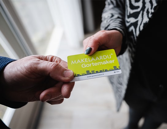 Overhandiging van visitekaartje door makelaar aan klant tijdens kennismaking