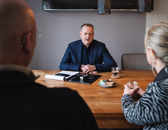 Makelaar in gesprek met klanten tijdens persoonlijk woonadvies in Assen