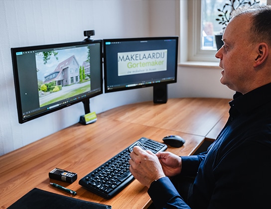 Makelaar werkt op kantoor aan digitale presentatie van een woning in Assen